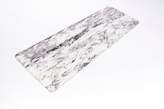 Całkowicie rozłożona szaro-biała mata TPE do jogi. Zdjęcie wykonane z góry pod lekkim kątem.