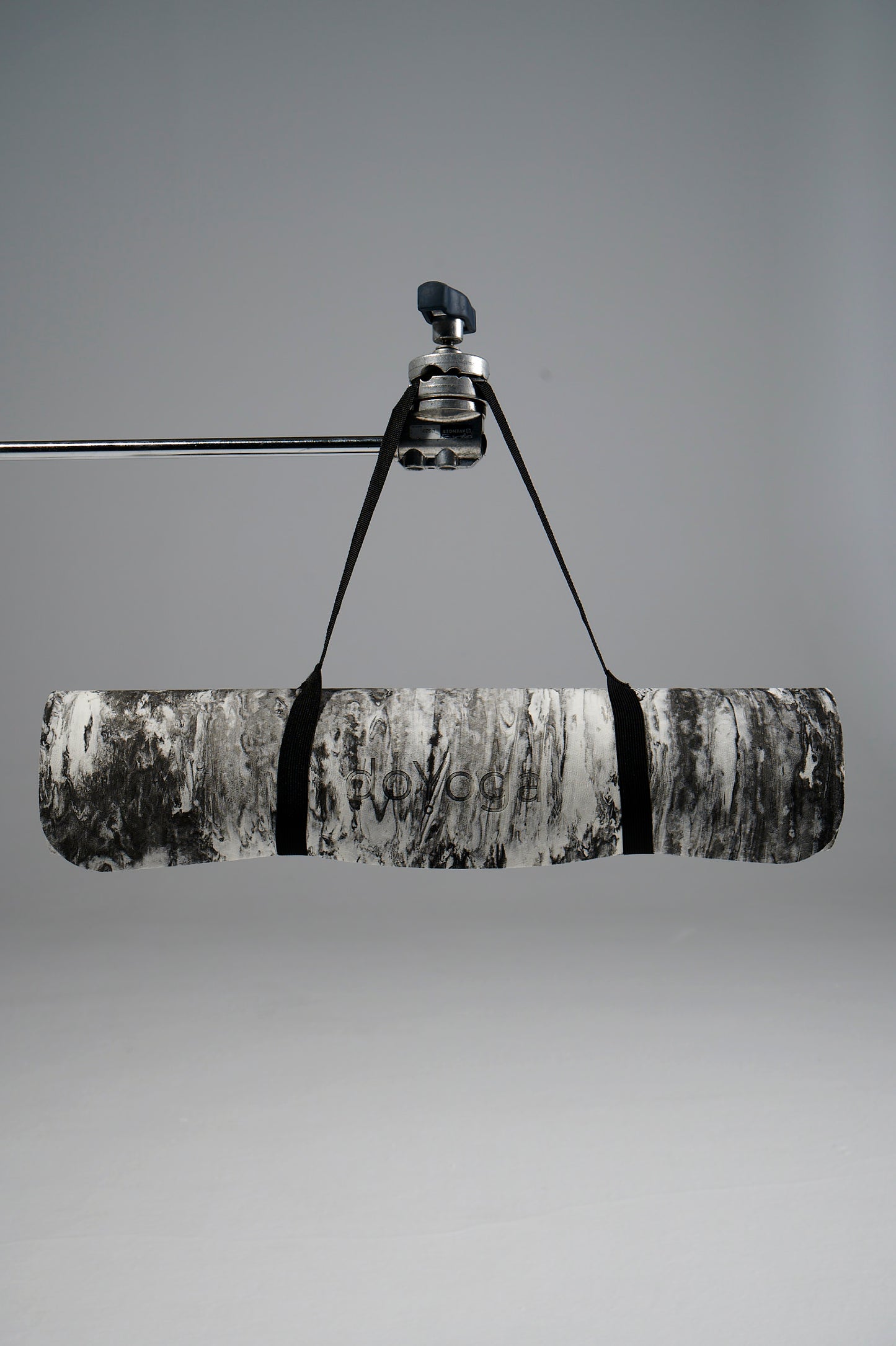 Zrolowana mata do jogi doYoga, wisząca na statywie. 