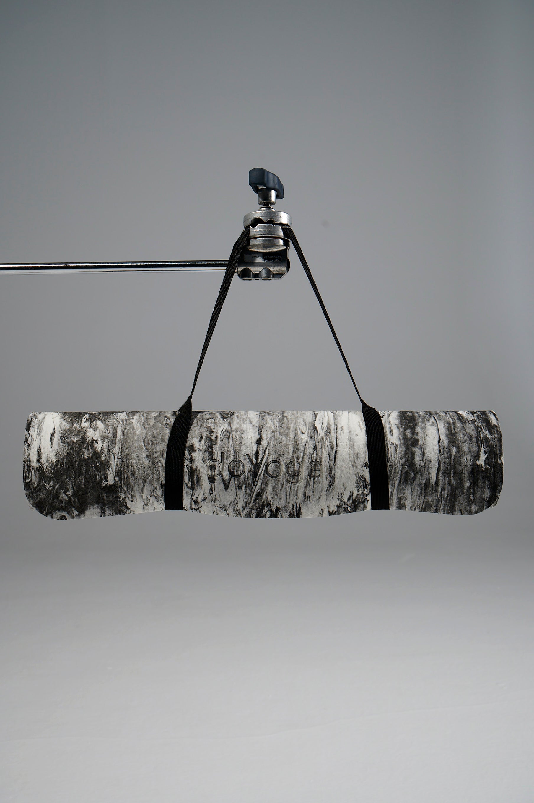 Zrolowana mata do jogi doYoga, wisząca na statywie. 